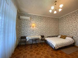 a bedroom with a bed and a table and chairs at Двухкомнатная квартира в самом ЦЕНТРЕ Николаева !СОБОРНАЯ! 3 РАЗД МЕСТА in Mykolaiv
