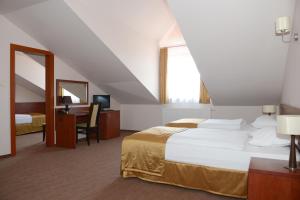 pokój hotelowy z dużym łóżkiem i biurkiem w obiekcie Hotel Vis a Vis Łańcut w Łańcucie