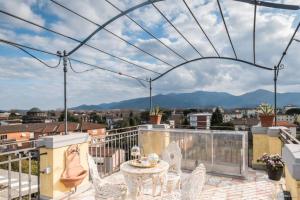 een patio met een tafel en stoelen op een balkon bij Casa Maria - ATTICO DI LUSSO VICINO ALLE MURA in Lucca