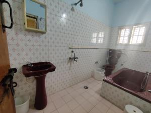 a bathroom with a sink and a tub and a toilet at Kavitha House Homestay in Mysore +19 photos