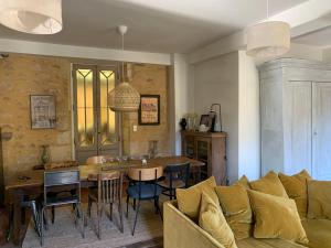 een woonkamer met een bank en een tafel bij Villa Marguerite Chambres et Table d Hotes de charme in Cadouin