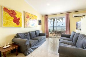 a living room with two couches and a table at Apartamento DANIELA in Port de Pollensa