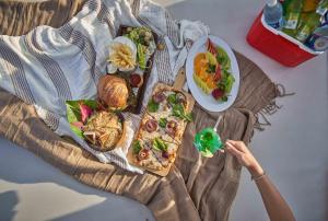 Cancun Sokhna Resort & Villas في العين السخنة: شخص يجلس على طاولة مع طبق من الطعام