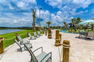 a group of chairs and tables next to a pool at Villa wPrivate Pool &Themed Rooms, near Disney in Kissimmee