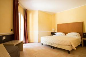 a bedroom with a bed and a large window at BV Airone Resort in Marina di Sibari