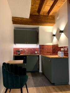 une cuisine avec des placards verts et une chaise verte dans l'établissement Luxe et Calme en Hyper Centre - La Cour des Bois, à Lyon