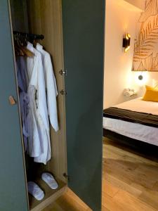 Cette chambre comprend un placard avec des vêtements blancs et un lit. dans l'établissement Luxe et Calme en Hyper Centre - La Cour des Bois, à Lyon