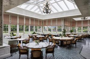 a dining room with tables and chairs and windows at The Gleneagles Hotel in Auchterarder
