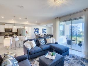 a living room with a blue couch and a kitchen at Updated Condo, 5 mi to Disney, On-site Water Park in Kissimmee