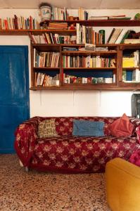 un sofá en una sala de estar con estanterías en Centro Studi Nuovarmonia, en Cedri