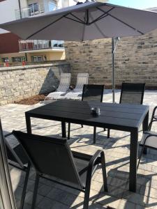 stół i krzesła z parasolem i laptopem w obiekcie Apartamenty Klifowa w Rewalu