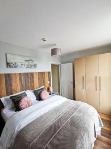 1 dormitorio con 1 cama blanca grande con almohadas rosas en Sunrise View 2 Bed Apartment Sleeps 4 Spa Bath, en Bridlington