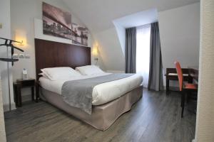 um quarto de hotel com uma cama grande e uma secretária em Best Western Lyon Saint-Antoine em Lyon