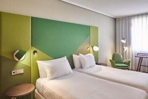 um quarto de hotel com uma cama e uma parede verde em Hotel Silken Indautxu em Bilbau