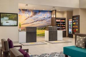 a hotel lobby with a large wall mural at La Quinta by Wyndham I-20 Longview South in Longview