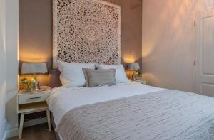 een slaapkamer met een groot wit bed en 2 nachtkastjes bij Vakantiewoning met privé sauna in Schoorl