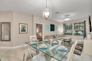 een woonkamer met een glazen tafel en stoelen bij 7664 Comrow Street #104 in Orlando