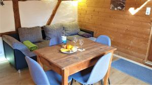 a wooden table with chairs and a bottle of water and fruit on it at Kaline 3 in Sandberg