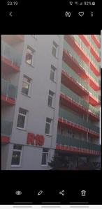 オラデアにあるApartament Karlaの赤い鍬看板が貼られた高層ビル