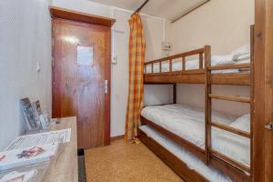 a small room with two bunk beds and a desk at La Vallée in Saint-Lary-Soulan