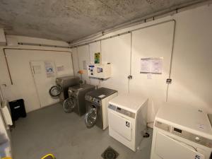 a laundry room with three washing machines in it at La Vallée in Saint-Lary-Soulan