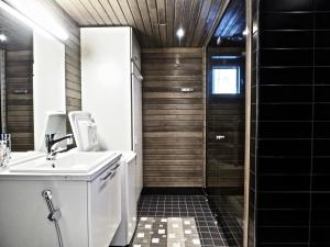 uma casa de banho com um lavatório e um chuveiro em Levin Stara 2 em Kittilä