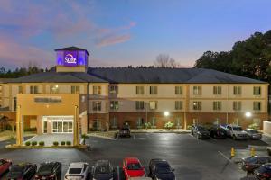 a hotel with cars parked in a parking lot at Sleep Inn & Suites Stockbridge Atlanta South in Stockbridge