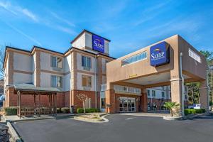 a hotel with a sign on the front of a building at Sleep Inn & Suites Stockbridge Atlanta South in Stockbridge