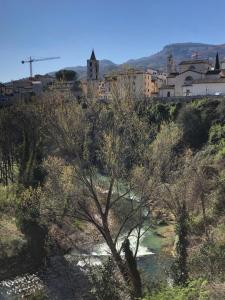 a town on top of a hill with a river at La casa sul fiume in Ascoli Piceno