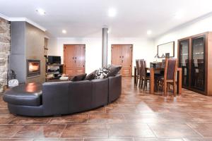 uma sala de estar com um sofá preto e uma mesa em RB Villa Cruzeiro em Monção