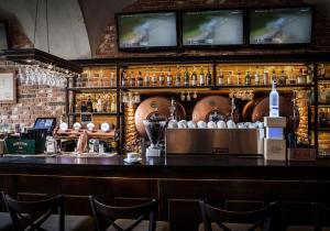 a bar with a counter with bottles of alcohol at Hotel Betmanowska Main Square Residence Adults Only in Krakow