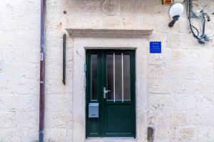 una puerta verde al lado de un edificio en Apartments Sara, en Dubrovnik