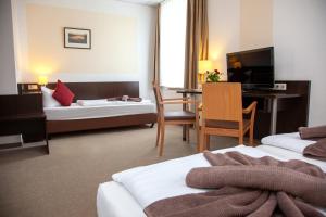 a hotel room with a bed and a desk at Seehotel Zum Löwen in Strasen