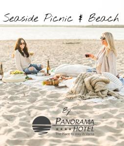 two women sitting on a blanket on the beach at Panorama Hotel - Free EV Charging Station in Varna City