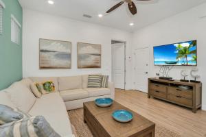 a living room with a couch and a tv at Gorgeous Margaritaville Cottage wPrivate Patio in Orlando