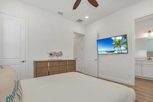 a bedroom with a bed and a tv on the wall at Gorgeous Margaritaville Cottage wPrivate Patio in Orlando