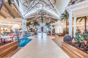 a lobby with palm trees and a chandelier at Gorgeous Margaritaville Cottage wPrivate Patio in Orlando