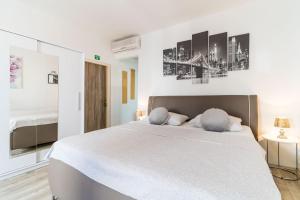 a bedroom with a large white bed with two pillows at Apartments Sara in Dubrovnik