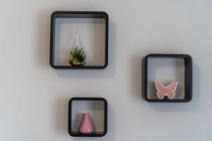 tres espejos en una pared con un jarrón y una mariposa en Apartments Sara, en Dubrovnik