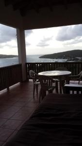 a balcony with tables and chairs and a view of the water at Vista Bella Apartments in Culebra