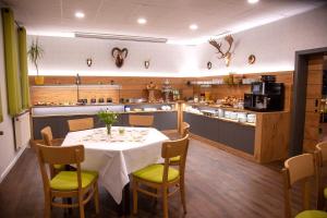 a dining room with a table and chairs and a kitchen at Seehotel Zum Löwen in Strasen