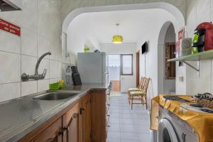 a kitchen with a sink and a refrigerator at Geo House in Vila do Bispo