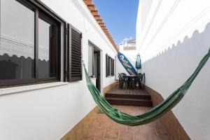 a hammock on the balcony of a house at Geo House in Vila do Bispo