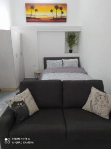 un divano nero in una camera con letto di Eilat vacation studio סטודיו נופש באילת a Eilat