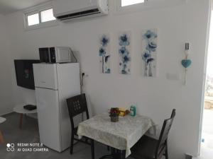 una cucina con tavolo e frigorifero bianco di Eilat vacation studio סטודיו נופש באילת a Eilat