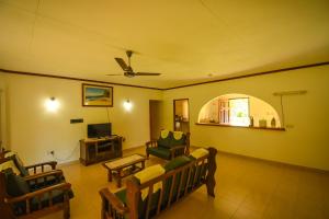 a living room with a couch and a tv at Skyblue Guesthouse - Self Catering in Baie Sainte Anne