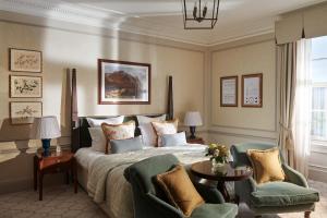 a bedroom with a bed and two chairs at The Gleneagles Hotel in Auchterarder
