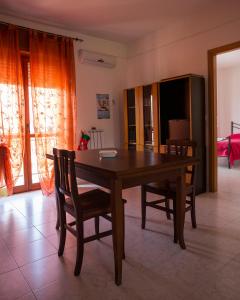 een eetkamer met een houten tafel en stoelen bij Casa Vacanze Isabella in Aliano