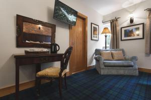 ケンダルにあるLyth Valley Country Houseのデスク、椅子、鏡が備わる客室です。