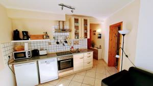 a kitchen with white cabinets and a stove top oven at Apartment Tintenfisch Strandkorb inkl in Göhren